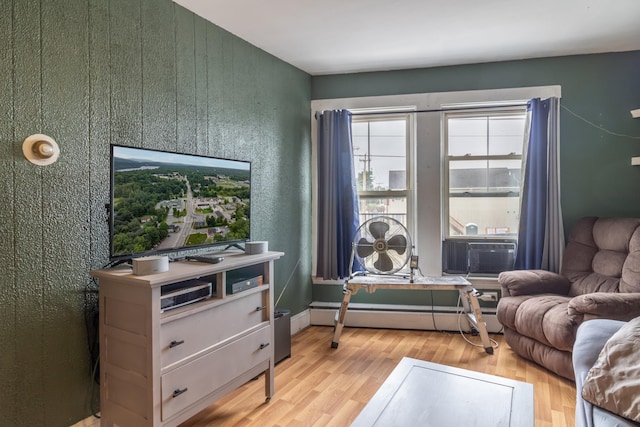 living room featuring light hardwood / wood-style flooring, baseboard heating, and cooling unit