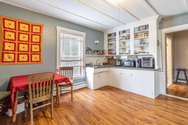 kitchen featuring a baseboard radiator, sink, and light hardwood / wood-style flooring