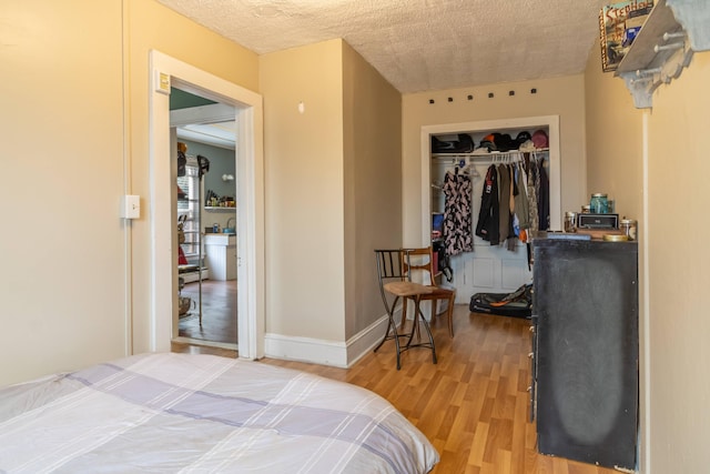 bedroom featuring light hardwood / wood-style floors, a closet, and a textured ceiling