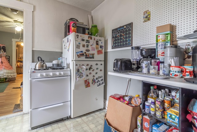 kitchen featuring ceiling fan, light wood-type flooring, a textured ceiling, and white appliances