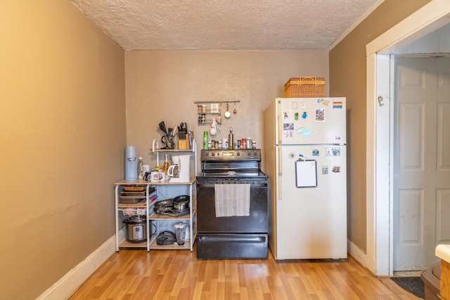 kitchen with light hardwood / wood-style floors, white refrigerator, electric stove, and a textured ceiling