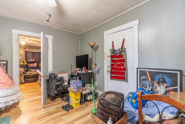 interior space with hardwood / wood-style floors, ceiling fan, and a textured ceiling