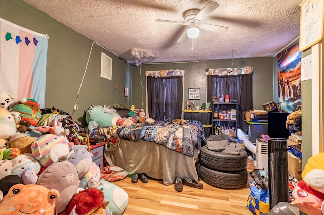 bedroom featuring ceiling fan, a textured ceiling, and hardwood / wood-style floors