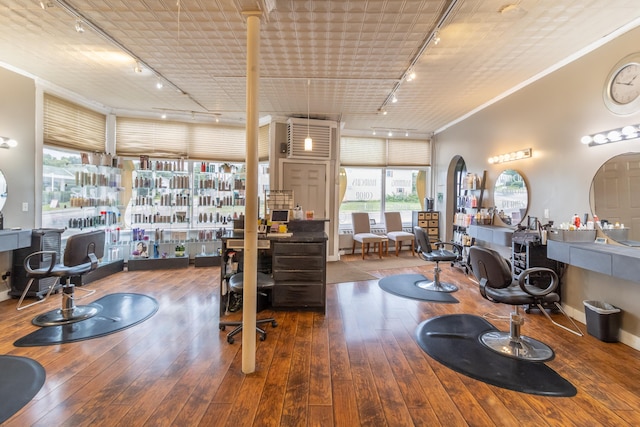 office with rail lighting, wood-type flooring, and ornamental molding