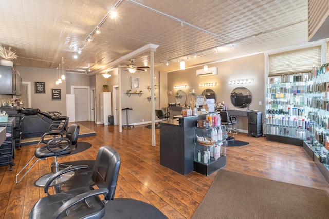 interior space with ceiling fan, rail lighting, a wall mounted AC, and hardwood / wood-style floors