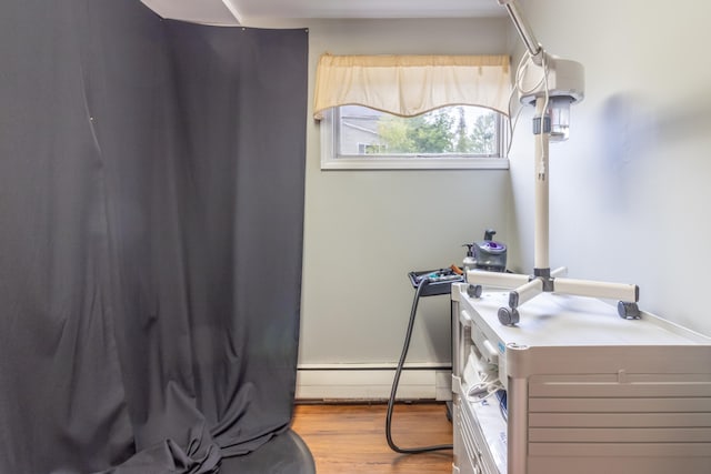 bathroom featuring hardwood / wood-style floors, a baseboard heating unit, and vanity