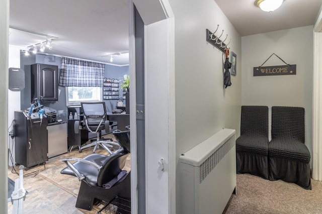 hallway featuring rail lighting, light tile patterned flooring, and radiator