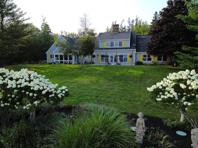 rear view of property featuring a patio and a yard