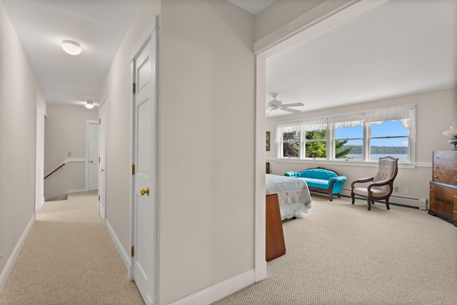 hall featuring light carpet and baseboard heating