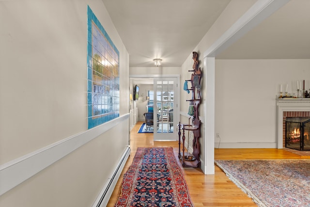 corridor with a baseboard radiator and hardwood / wood-style flooring