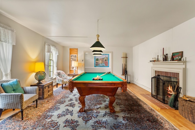 playroom featuring a brick fireplace, hardwood / wood-style flooring, and pool table