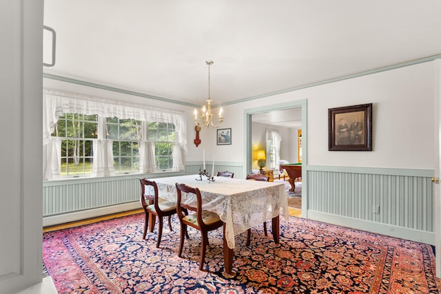 dining space featuring baseboard heating and a chandelier