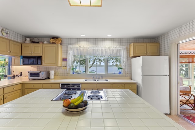 kitchen featuring sink, black appliances, tile countertops, and light brown cabinets