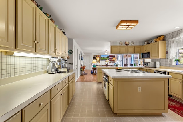 kitchen with tile countertops, tasteful backsplash, a center island, and ceiling fan