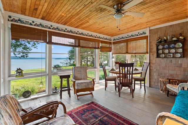 sunroom with wooden ceiling, a water view, and ceiling fan