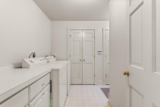 washroom with independent washer and dryer, light tile patterned floors, and cabinets