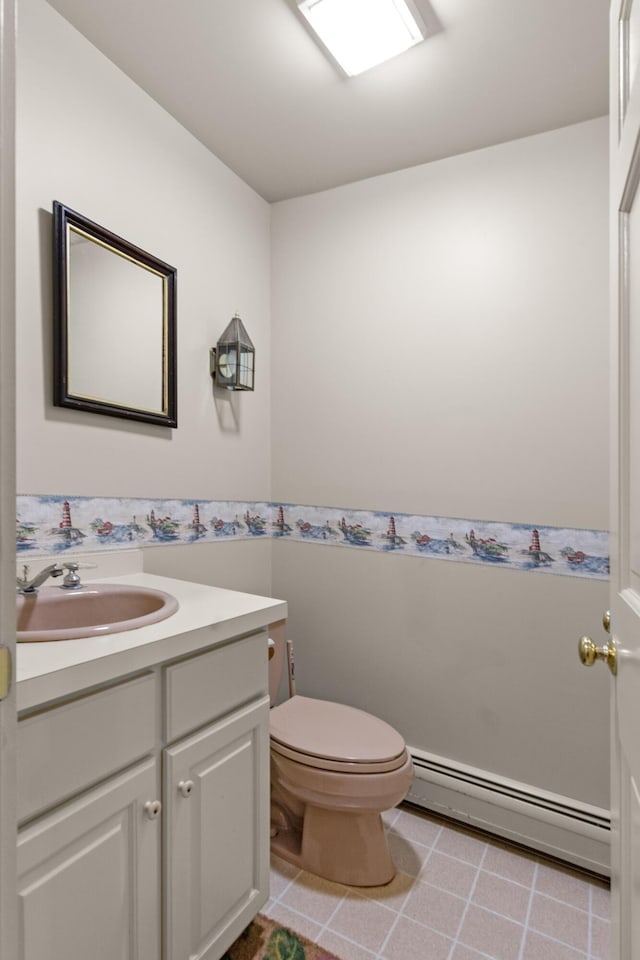 bathroom with toilet, vanity, a baseboard radiator, and tile patterned floors