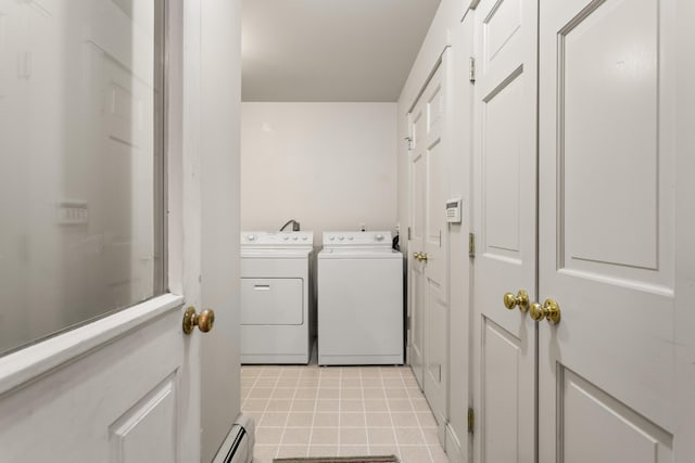 clothes washing area with baseboard heating, washing machine and clothes dryer, and light tile patterned floors