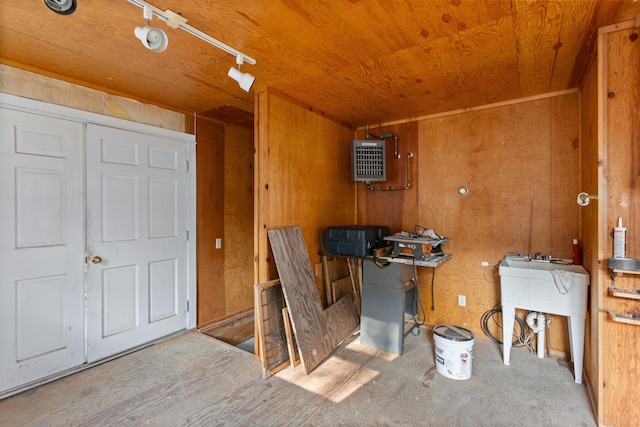 misc room with track lighting, wood ceiling, and wood walls