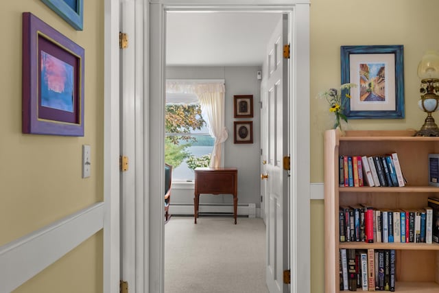 hallway with a baseboard radiator and light colored carpet