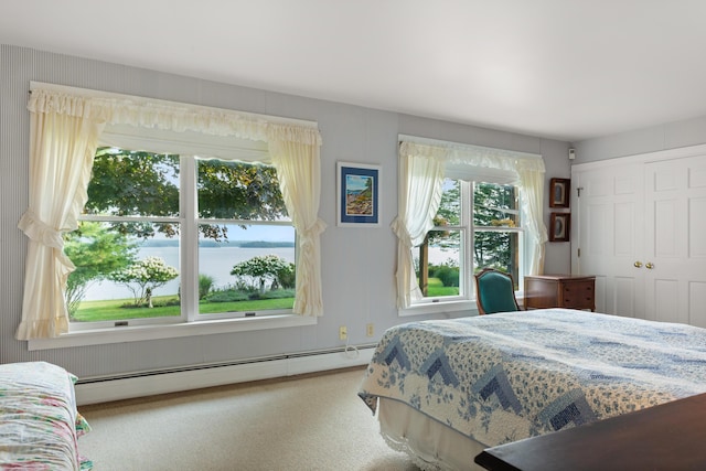 carpeted bedroom featuring baseboard heating and a water view