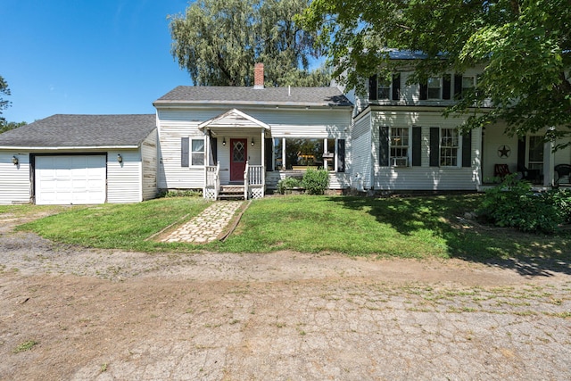 view of front of house featuring a garage, covered porch, and a front yard