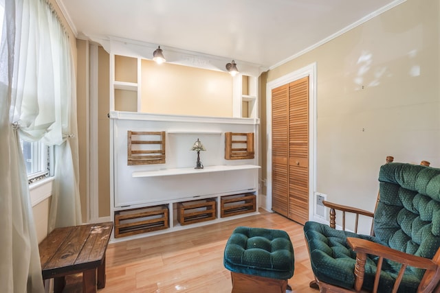 living area featuring ornamental molding, built in features, and light hardwood / wood-style floors