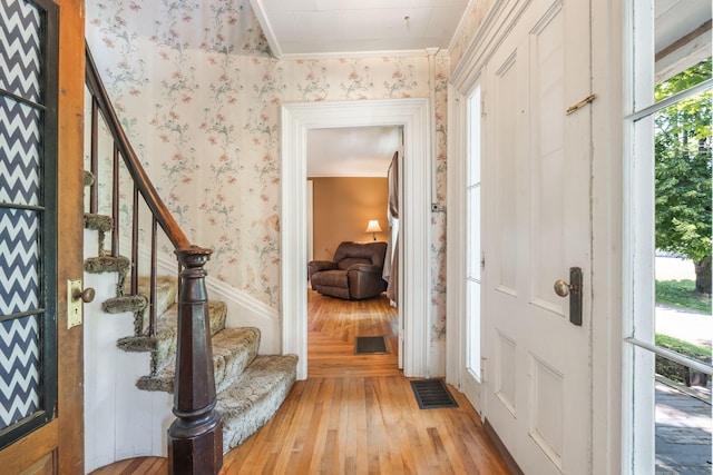 entrance foyer with light wood-type flooring and ornamental molding