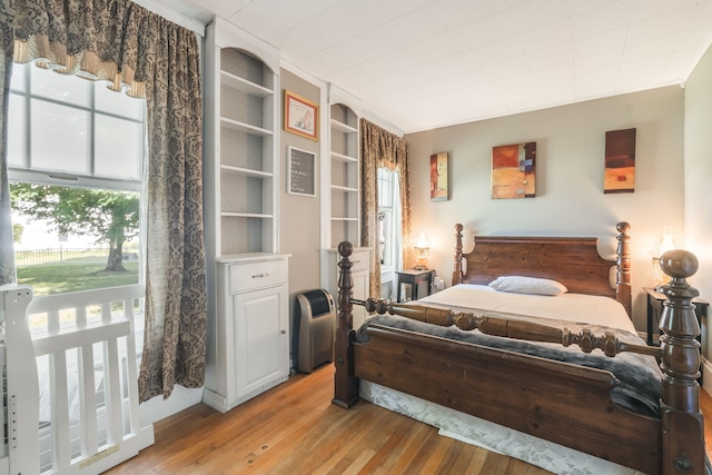 bedroom featuring light hardwood / wood-style floors and crown molding