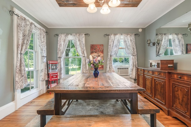 dining area featuring a notable chandelier, light wood-type flooring, cooling unit, and crown molding