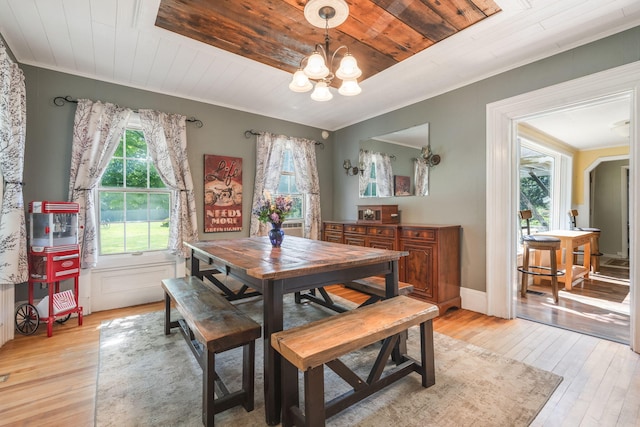 dining space featuring crown molding, light wood-type flooring, a chandelier, and wood ceiling