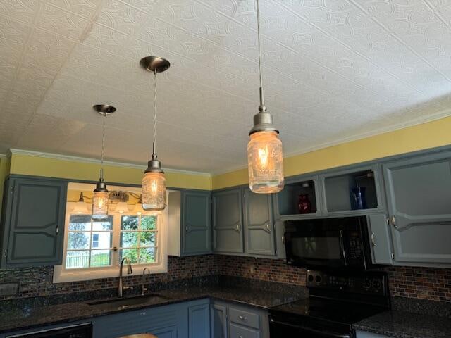 kitchen with backsplash, electric stove, sink, and hanging light fixtures