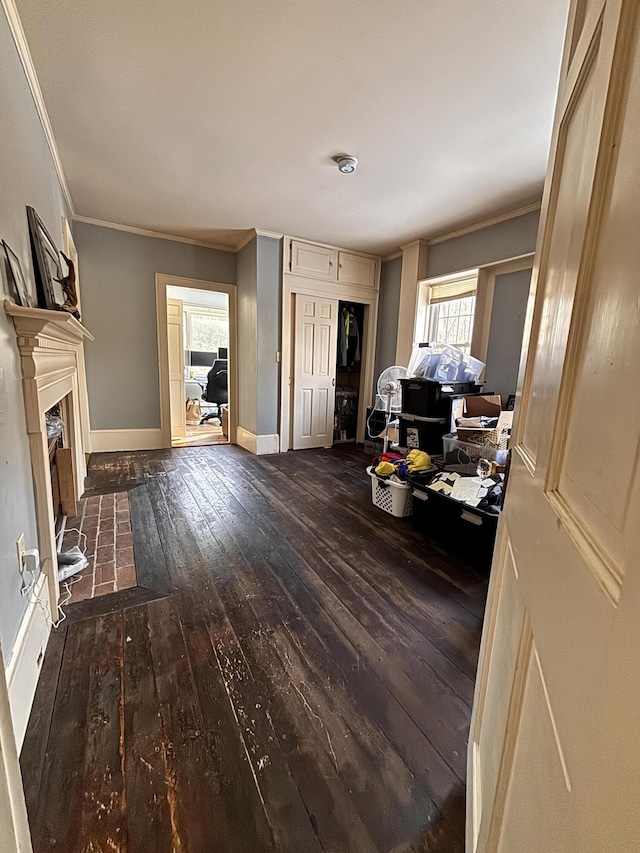 living room featuring ornamental molding, a brick fireplace, and dark wood-type flooring