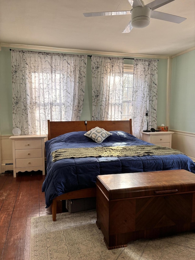 bedroom featuring hardwood / wood-style flooring, ceiling fan, crown molding, and a baseboard heating unit