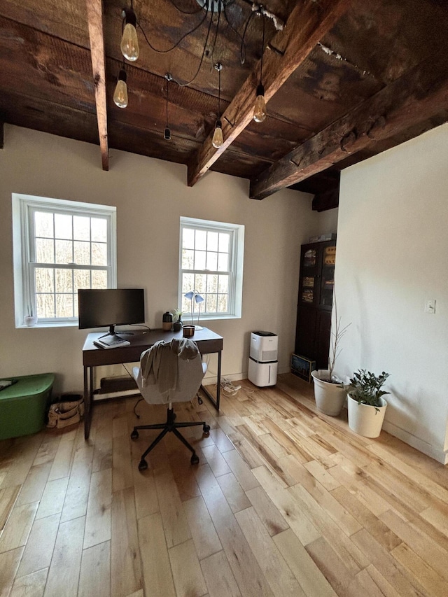 office with a healthy amount of sunlight, beam ceiling, light hardwood / wood-style flooring, and wooden ceiling