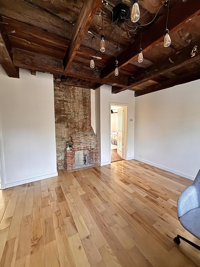 unfurnished living room with beam ceiling, wooden ceiling, and light wood-type flooring