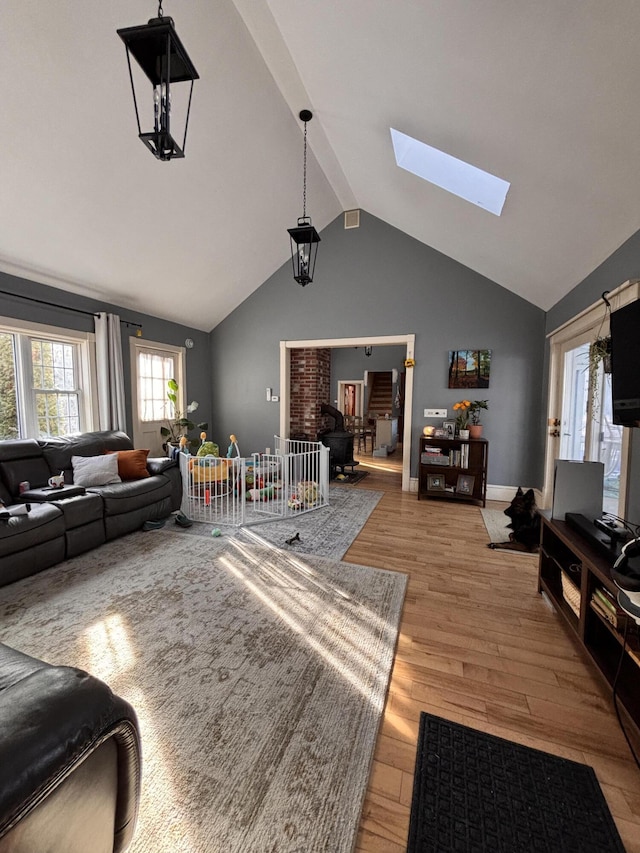 living room with light hardwood / wood-style flooring and lofted ceiling with skylight