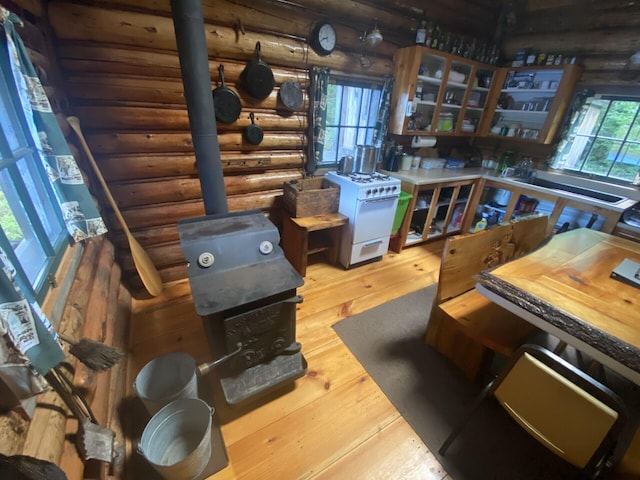 LOT14 Rowe Pond Rd, Pleasant Ridge Plt, ME 04920 - kitchen with log walls, a wood stove, white gas stove, wood-type flooring, and glass insert cabinets