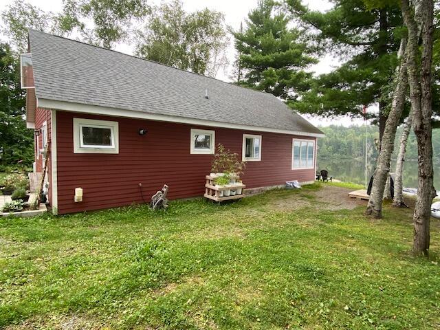 rear view of property featuring a yard