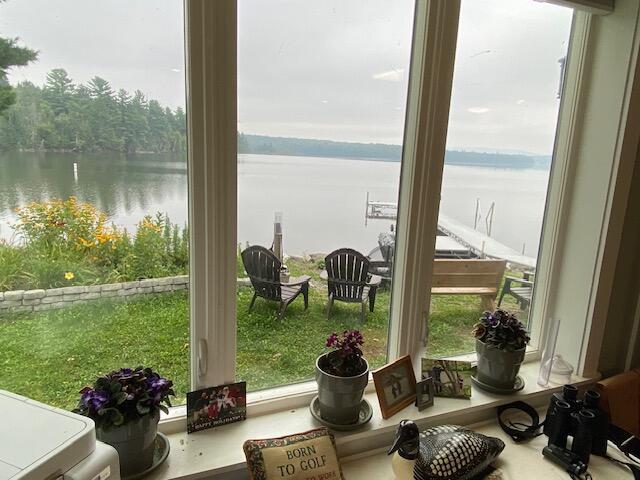 sunroom / solarium featuring a water view and a healthy amount of sunlight