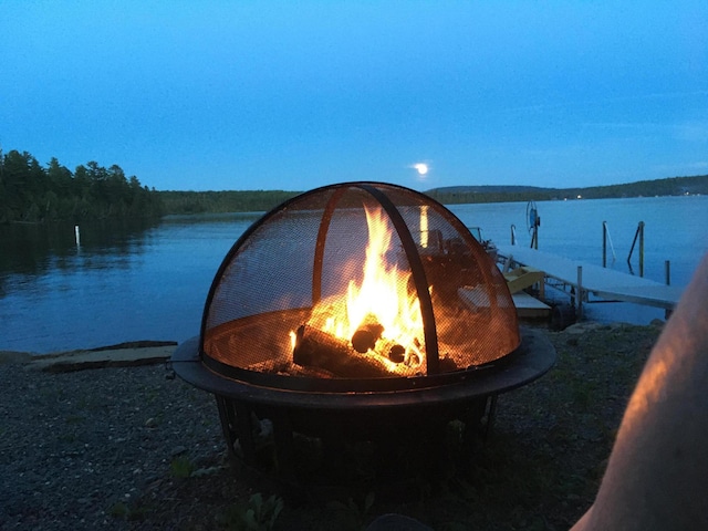 exterior space with a water view and an outdoor fire pit