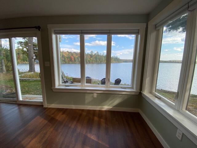 unfurnished sunroom featuring a water view