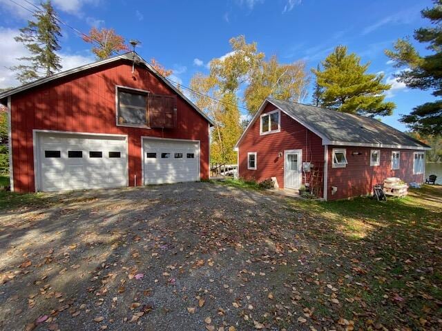 view of property exterior featuring a garage and an outbuilding