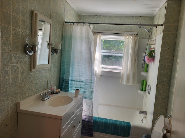 bathroom featuring vanity, shower / bath combo with shower curtain, and tile walls