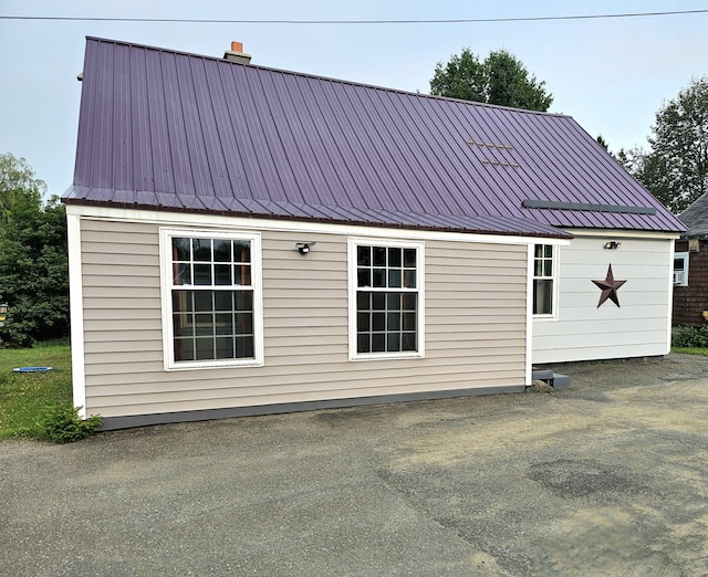 exterior space with metal roof and a chimney