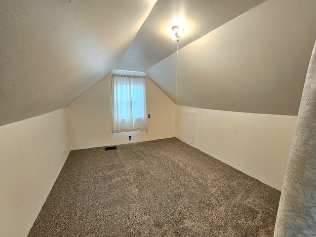 bonus room featuring lofted ceiling, carpet, and visible vents