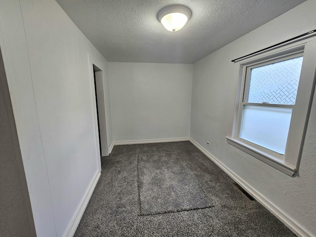 carpeted spare room with a textured ceiling