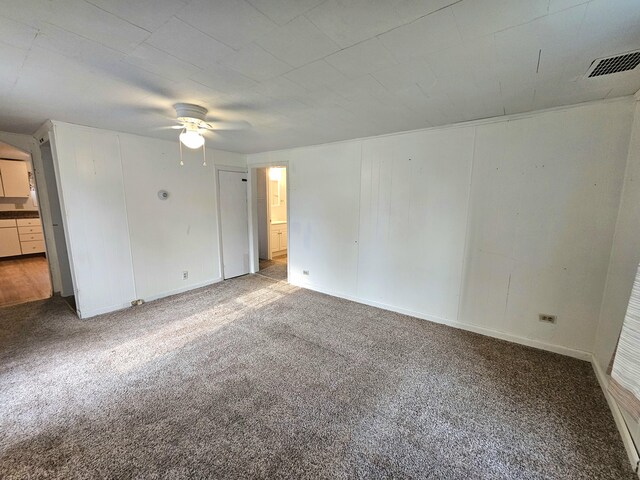 empty room with ceiling fan and carpet floors