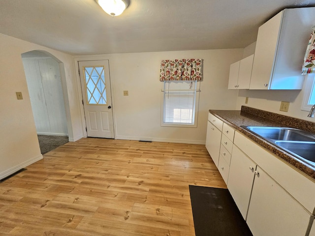 kitchen featuring sink, light hardwood / wood-style flooring, and white cabinets