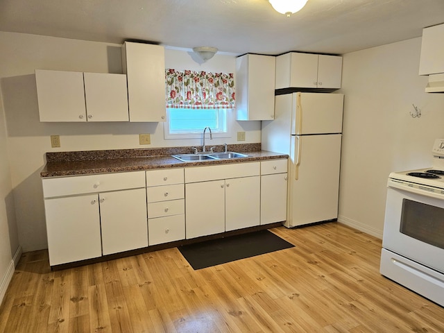 kitchen featuring dark countertops, white appliances, light wood-style flooring, and a sink